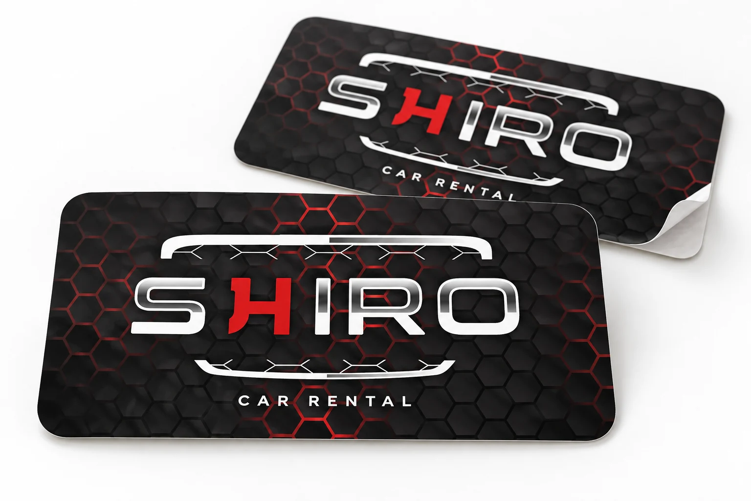 Wizualizacja dwóch naklejek SHIRO Car Rental z czarno-czerwonym wzorem sześciokątów na białym tle.